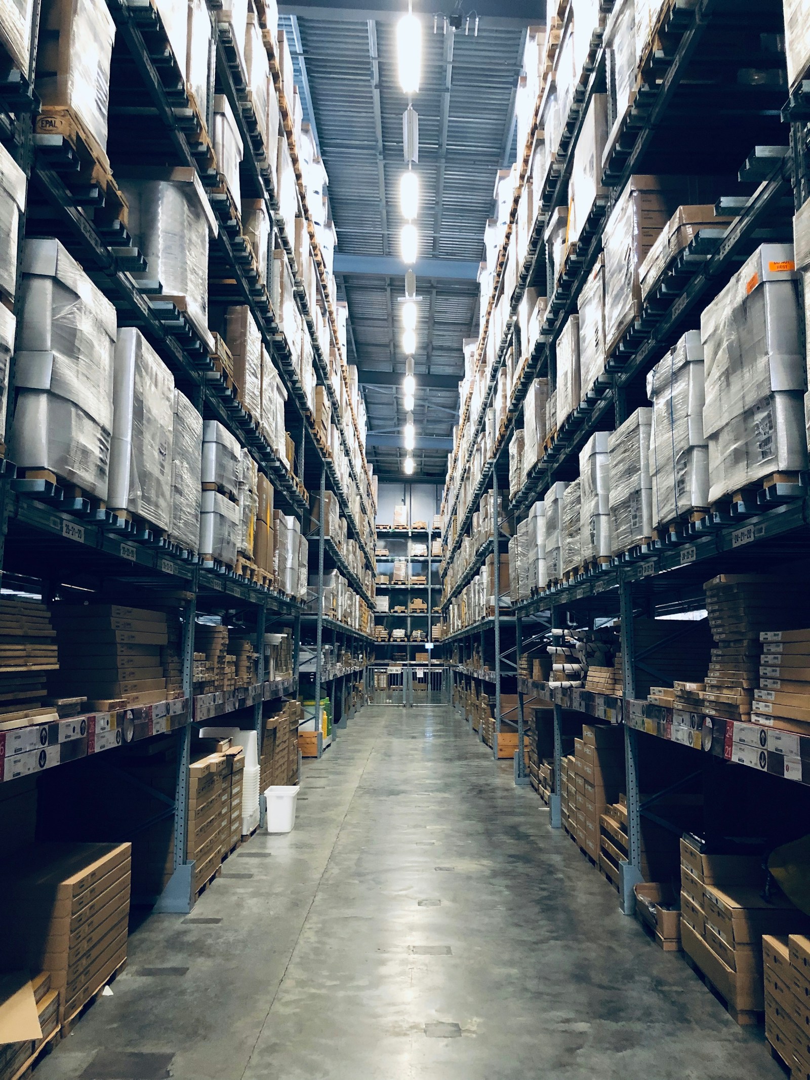 Tall racking aisle inside a brightly lit fulfillment warehouse