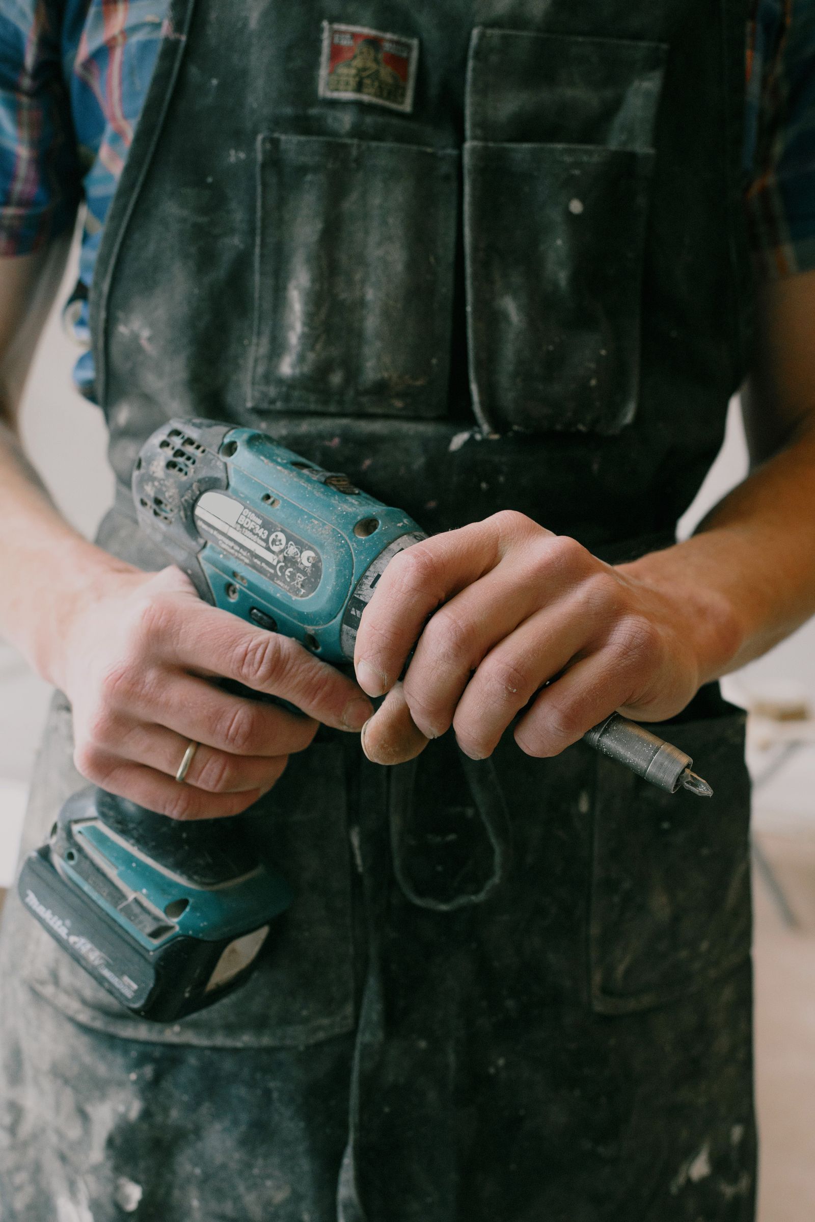 Installer's hands loading a bit into a cordless drill on a job