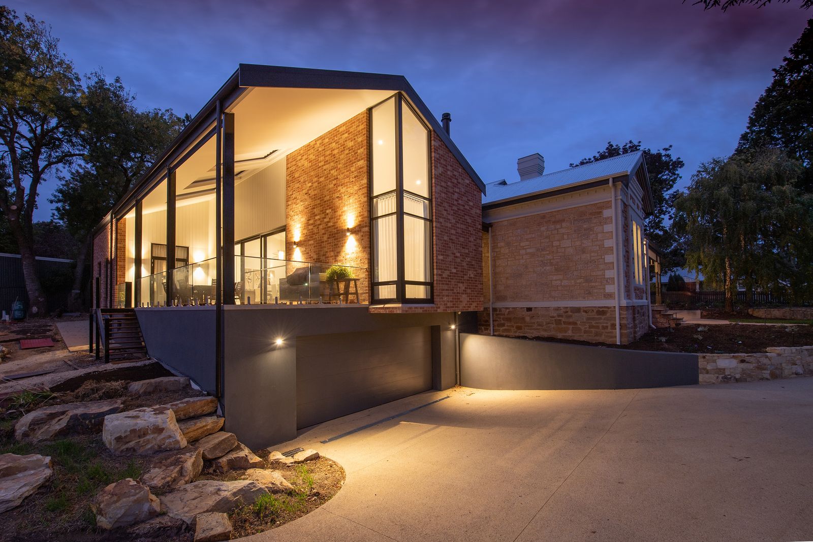 Warm front entrance of a brick home glowing at dusk