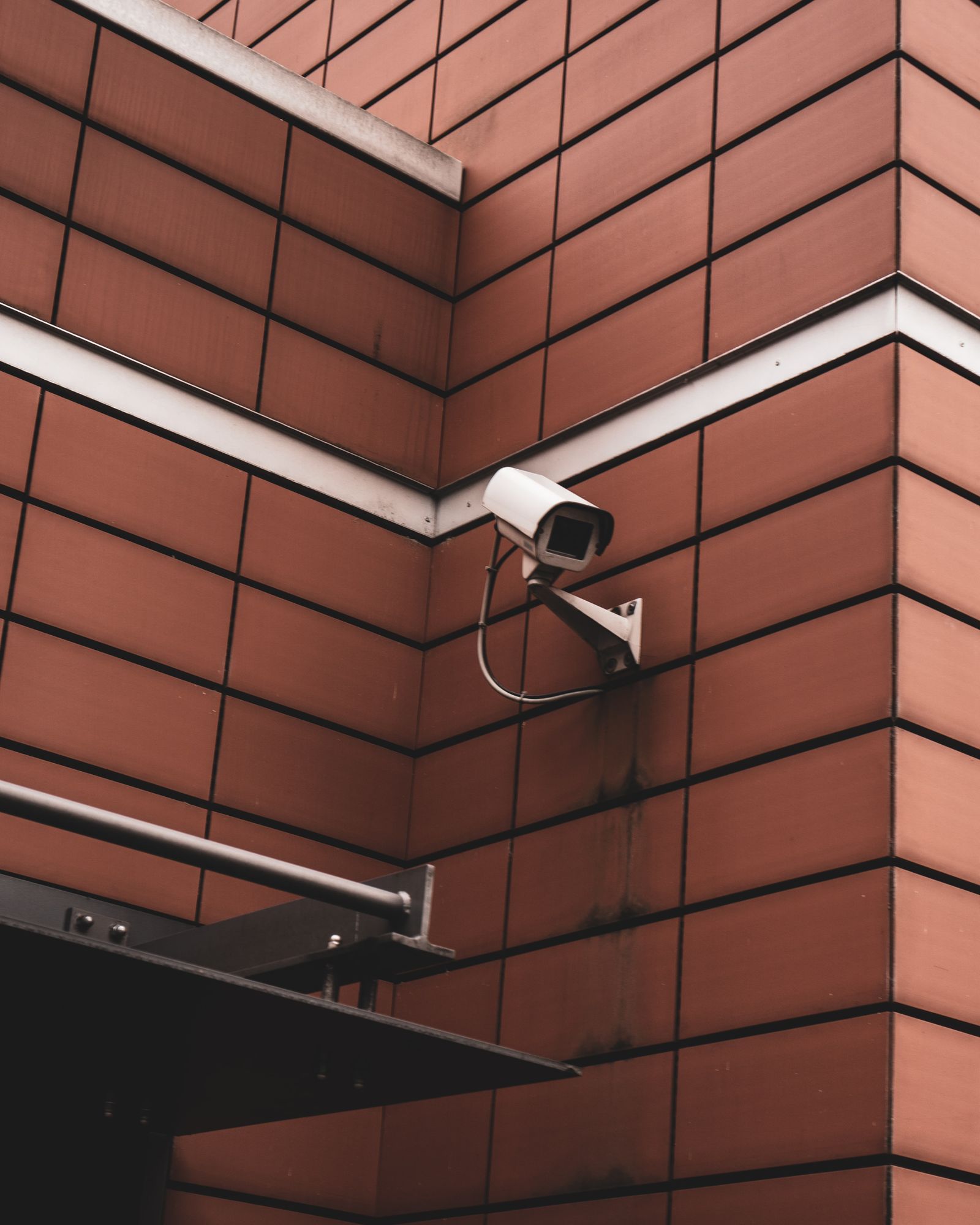 Security camera mounted on the corner of a brick commercial building