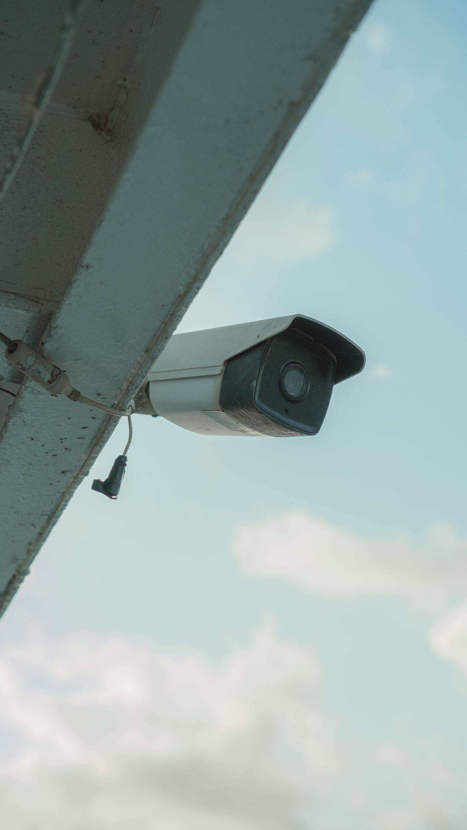 Outdoor security camera installed under the eaves of a house